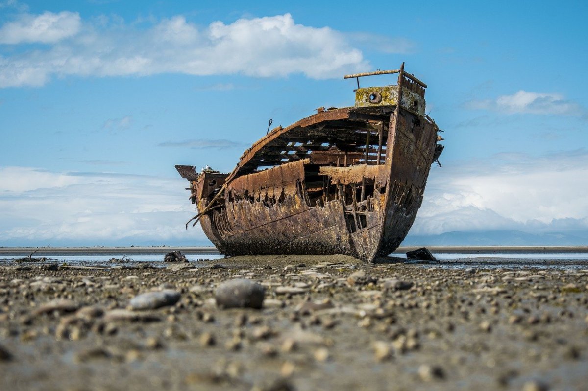 Photograph of an old row-boat, left to decay on the beach.